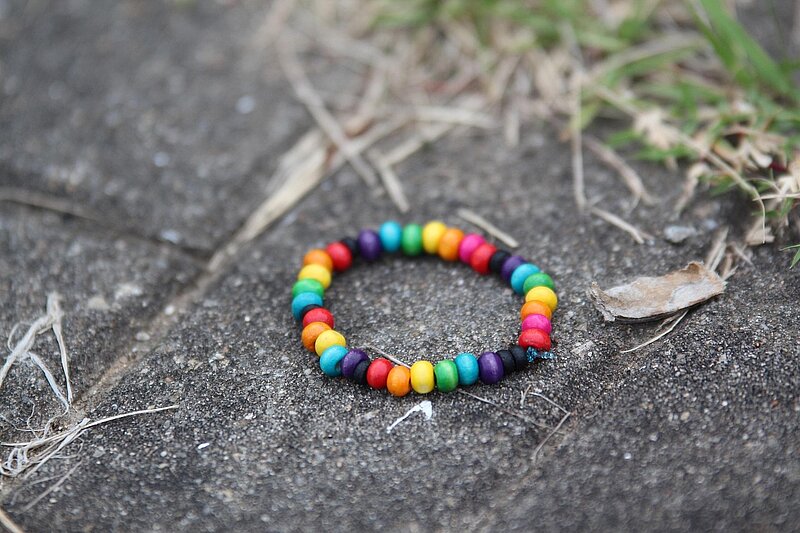 Bunte Perlenkette liegt auf der Straße.